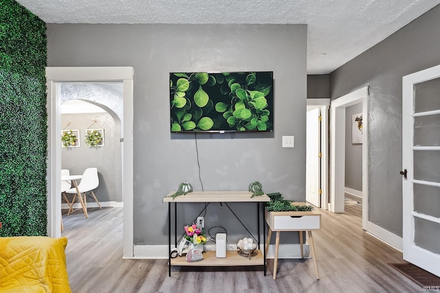 interior space with a textured ceiling and hardwood / wood-style flooring