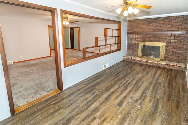 unfurnished living room featuring ornamental molding, a brick fireplace, ceiling fan, and hardwood / wood-style flooring