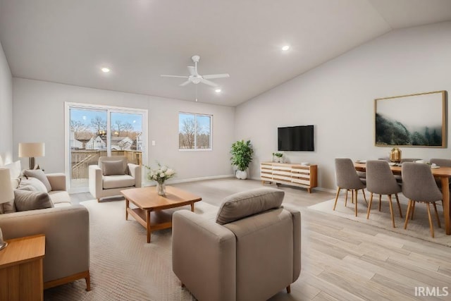 living room with ceiling fan, vaulted ceiling, and light hardwood / wood-style floors