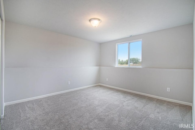 carpeted spare room with vaulted ceiling