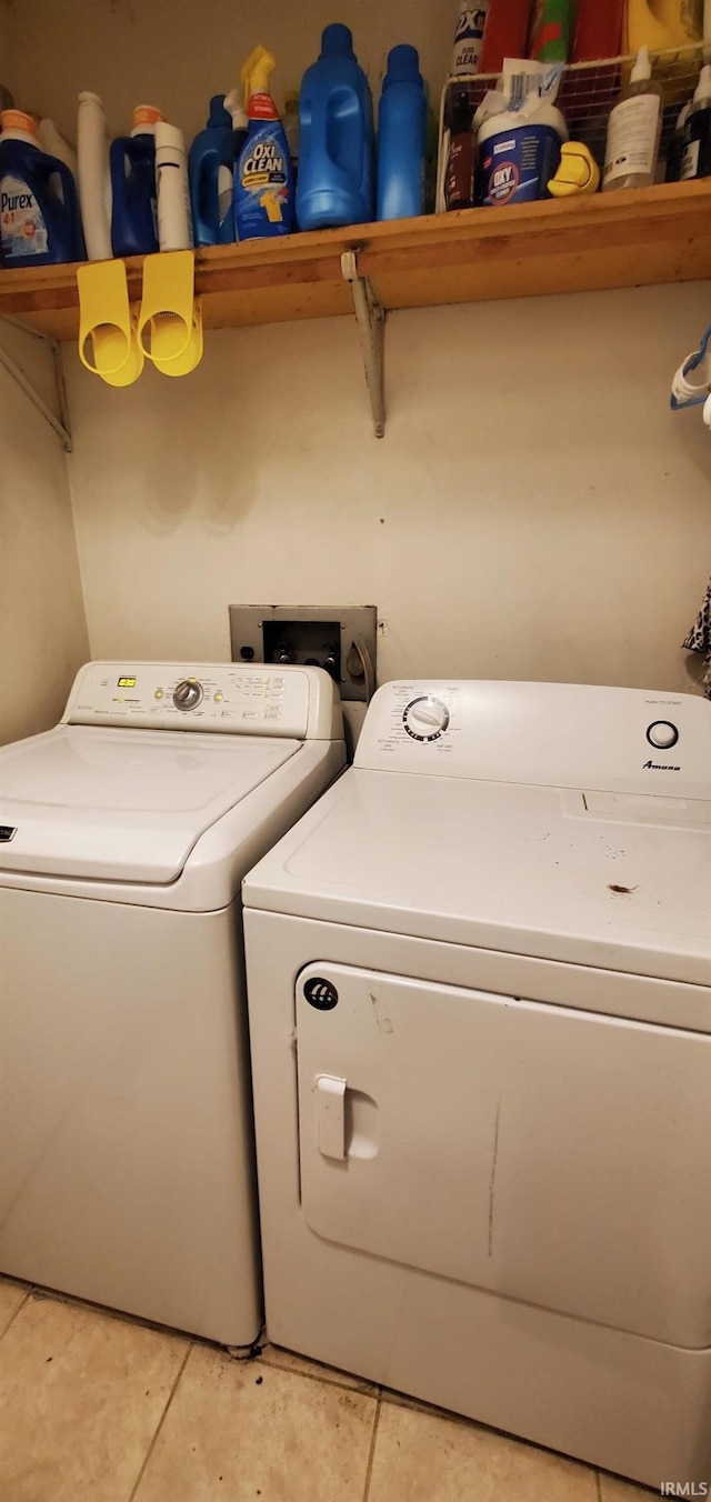 laundry area featuring washing machine and clothes dryer and tile patterned flooring