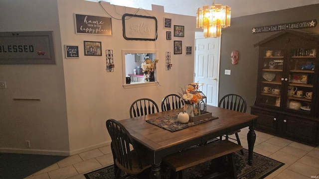 tiled dining room with a notable chandelier