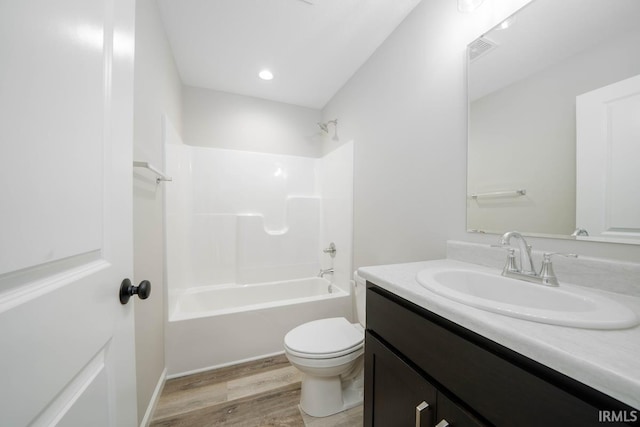 full bathroom featuring wood-type flooring, vanity, bathtub / shower combination, and toilet