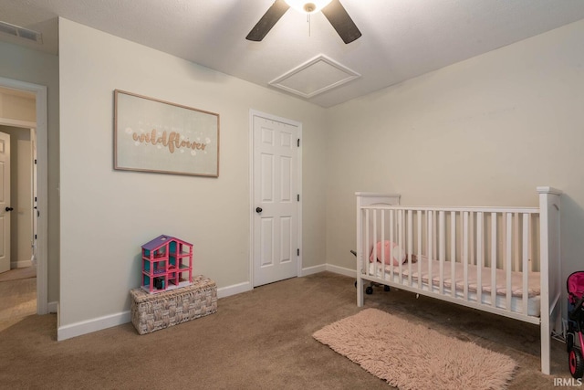 unfurnished bedroom featuring ceiling fan, a nursery area, and carpet floors