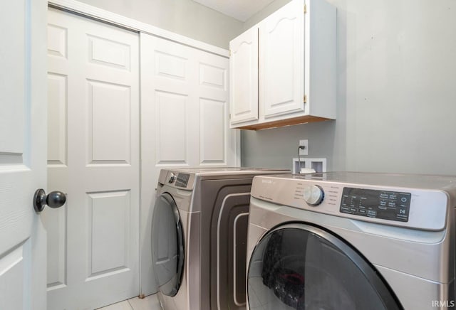 washroom featuring cabinets, light tile patterned floors, and separate washer and dryer