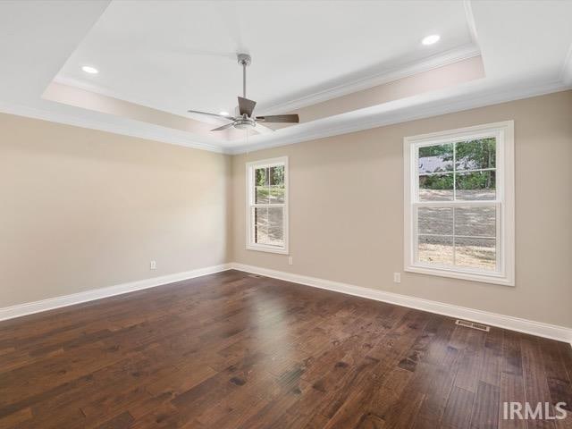 spare room featuring ceiling fan, a tray ceiling, and dark hardwood / wood-style floors