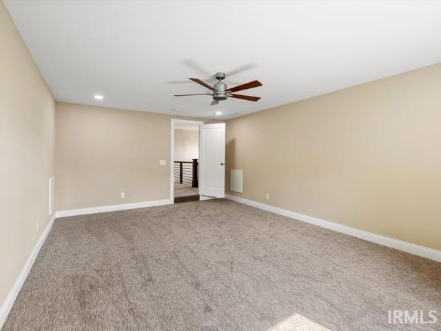 carpeted empty room featuring ceiling fan