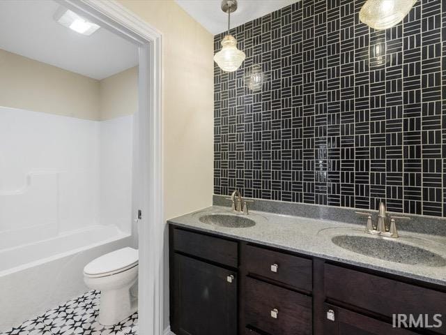 full bathroom with vanity, tiled shower / bath combo, toilet, and tile patterned flooring