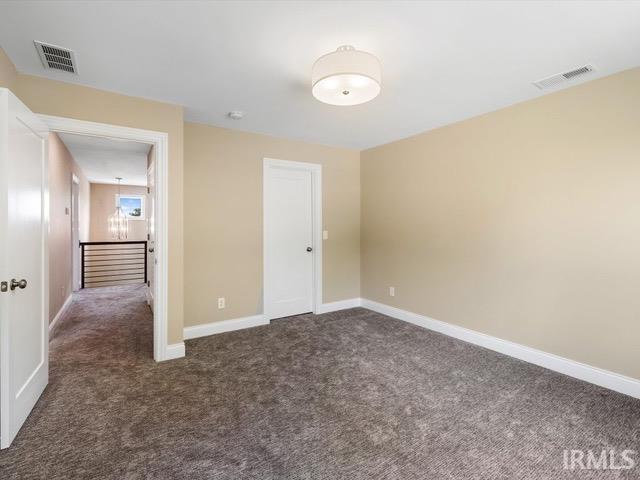 unfurnished bedroom with dark carpet