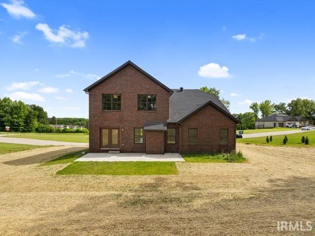 rear view of property featuring a lawn and a patio area