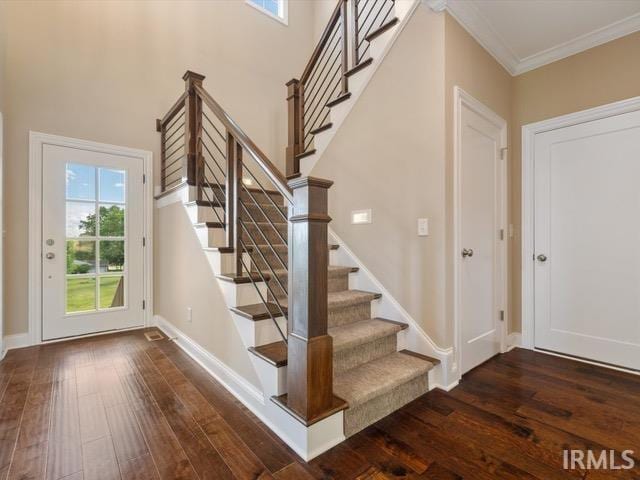 stairs featuring hardwood / wood-style flooring and crown molding