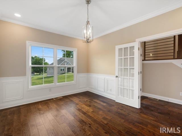 unfurnished dining area with ornamental molding, a notable chandelier, and dark hardwood / wood-style flooring