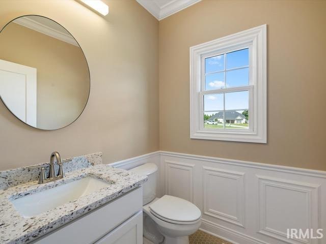 bathroom with crown molding, vanity, and toilet