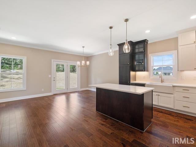 kitchen with pendant lighting, a kitchen island, and a healthy amount of sunlight