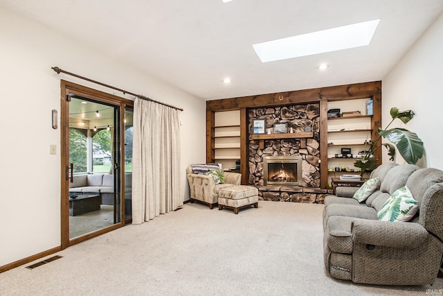 living room with a skylight, carpet floors, and a fireplace