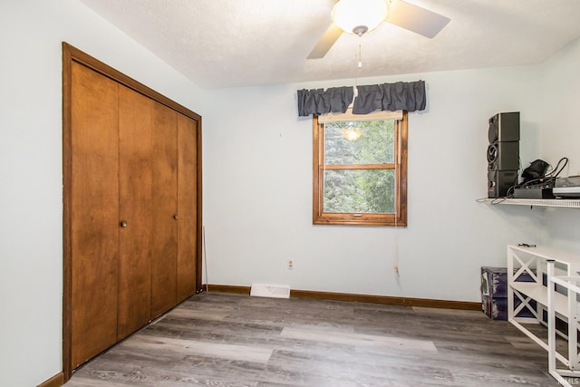 bedroom featuring wood-type flooring, a closet, ceiling fan, and a textured ceiling