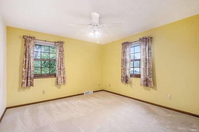 carpeted spare room with ceiling fan and a healthy amount of sunlight