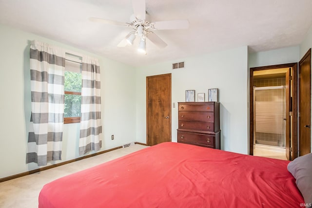 bedroom with ceiling fan, light colored carpet, and ensuite bathroom