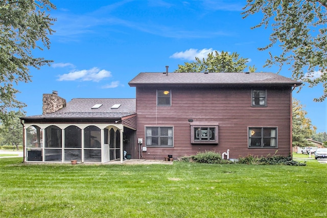 back of property with a lawn and a sunroom