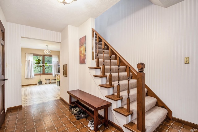 staircase featuring tile patterned flooring and a textured ceiling