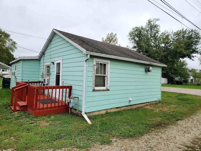 view of side of property with a lawn and a wooden deck