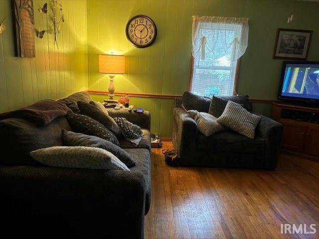 living room featuring wood-type flooring and wood walls