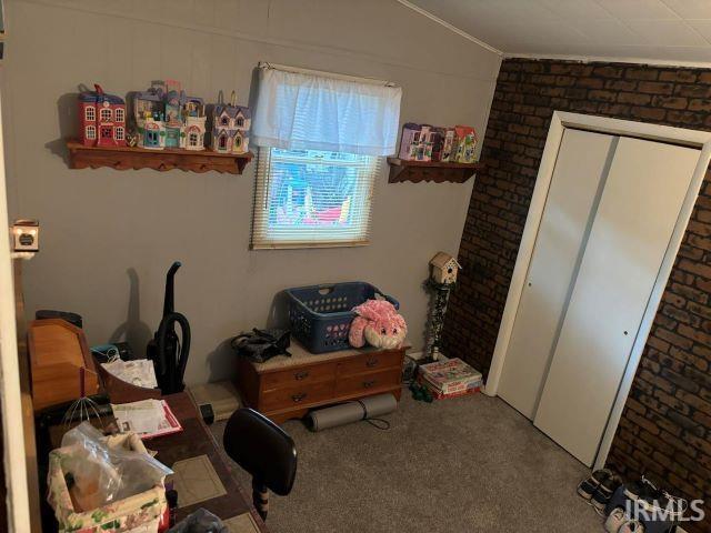 506 Meredith St, Washington, IN 47501 - carpeted bedroom featuring vaulted ceiling, brick wall, and ornamental molding