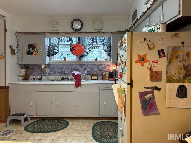 506 Meredith St, Washington, IN 47501 - kitchen featuring freestanding refrigerator, light countertops, and decorative backsplash