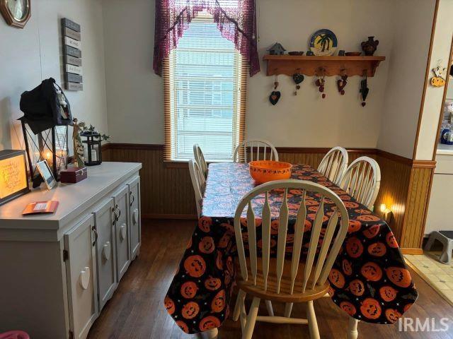 dining area featuring wood walls and dark hardwood / wood-style floors