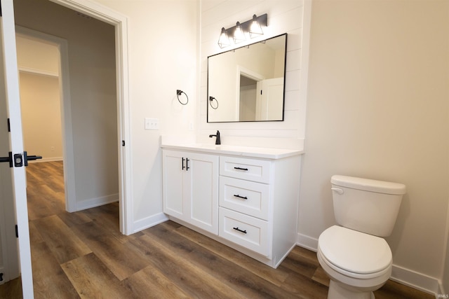 bathroom with wood-type flooring, vanity, and toilet