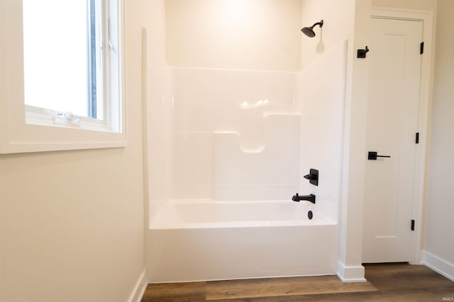 bathroom with hardwood / wood-style floors and shower / bathtub combination