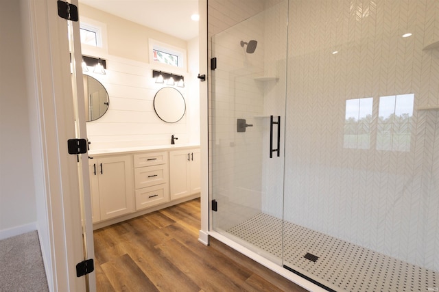 bathroom with walk in shower, wood-type flooring, and vanity