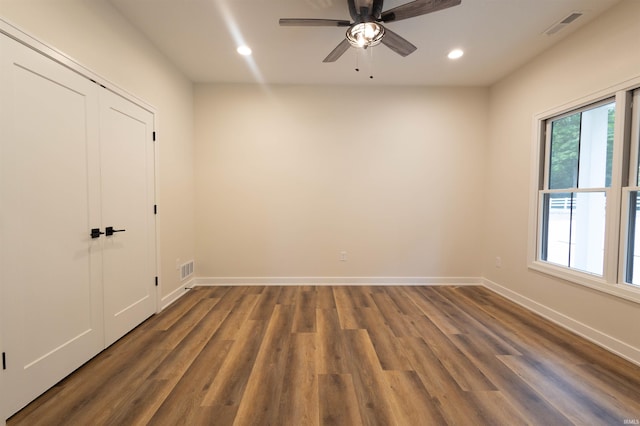 unfurnished room with ceiling fan and dark wood-type flooring