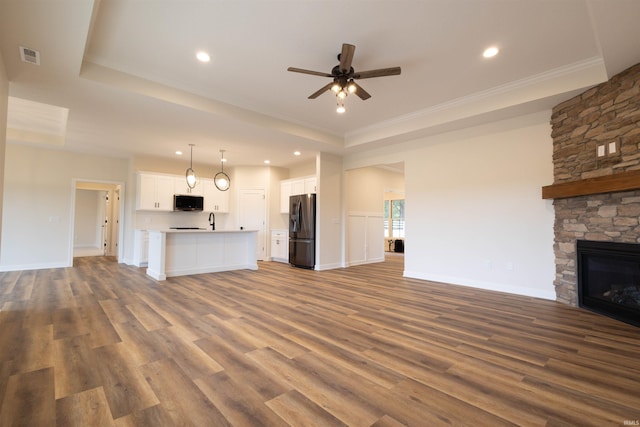 unfurnished living room with a fireplace, ceiling fan, ornamental molding, hardwood / wood-style floors, and sink