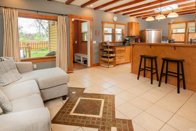 living room with light tile patterned floors and beamed ceiling