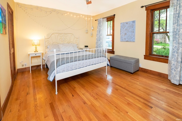 bedroom with multiple windows and hardwood / wood-style floors