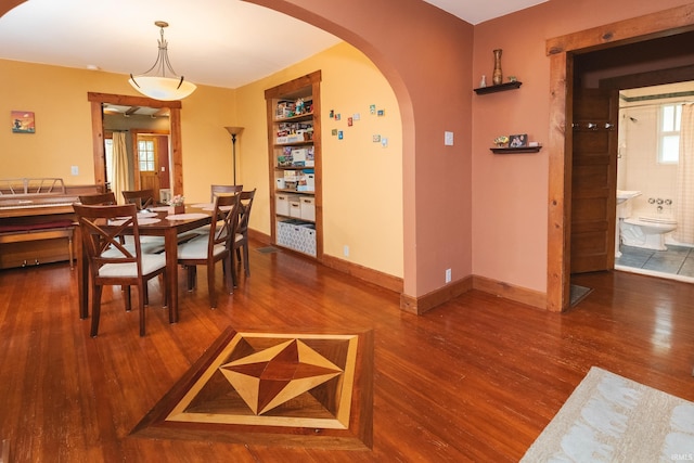 dining area with wood-type flooring and built in features