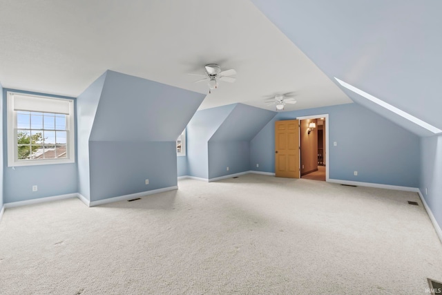 additional living space featuring vaulted ceiling, ceiling fan, and light colored carpet