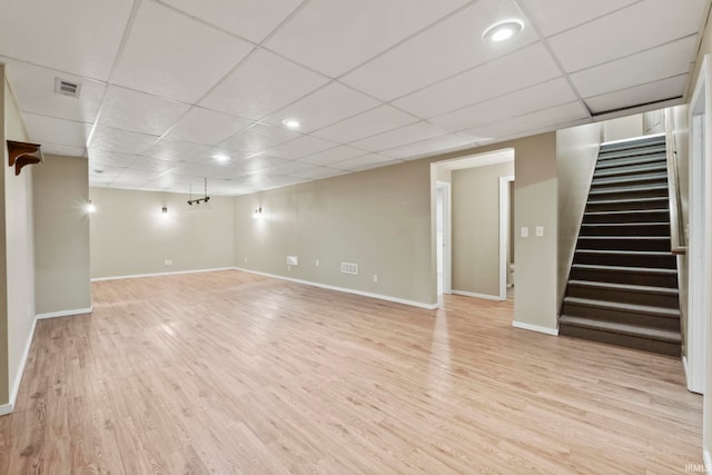 basement with a drop ceiling and light wood-type flooring