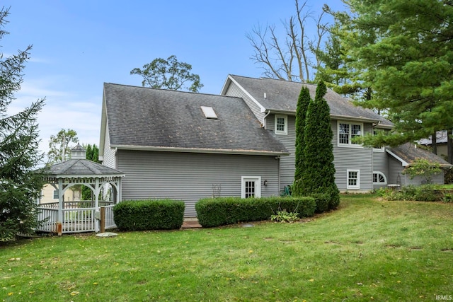 rear view of house featuring a gazebo and a lawn