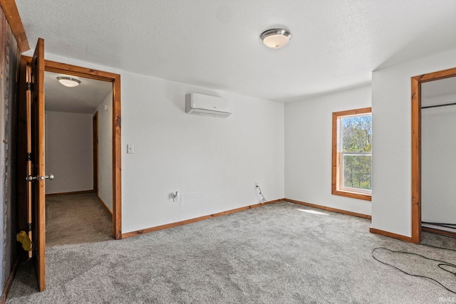 unfurnished bedroom with light carpet, a textured ceiling, and a wall mounted AC