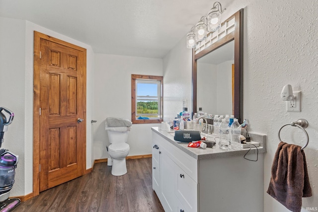 bathroom with vanity, hardwood / wood-style floors, toilet, and a textured ceiling