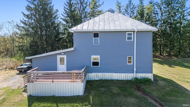 view of side of home with a wooden deck and a yard