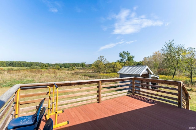 wooden deck featuring an outdoor structure and a rural view