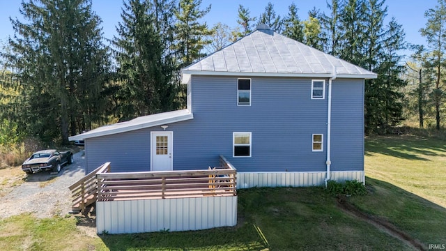 view of home's exterior featuring a wooden deck and a lawn