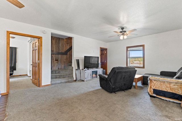 carpeted living room featuring a textured ceiling and ceiling fan