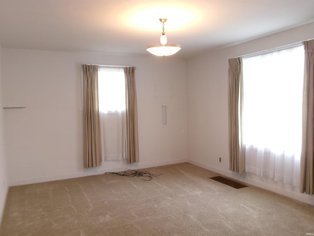 unfurnished room with carpet and plenty of natural light