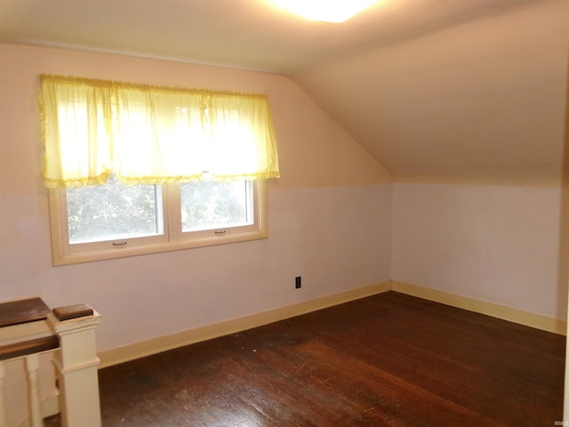 additional living space with dark hardwood / wood-style floors and vaulted ceiling