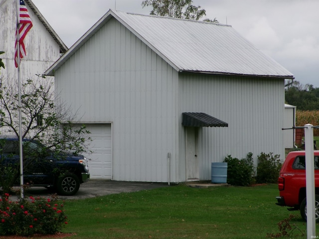 view of side of property featuring a garage and a yard