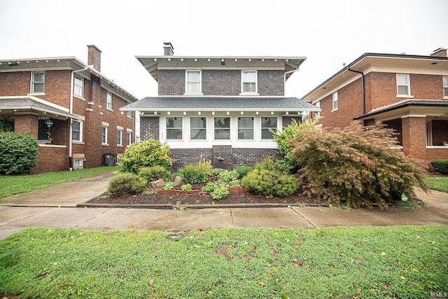 view of front of house with central AC unit and a front lawn